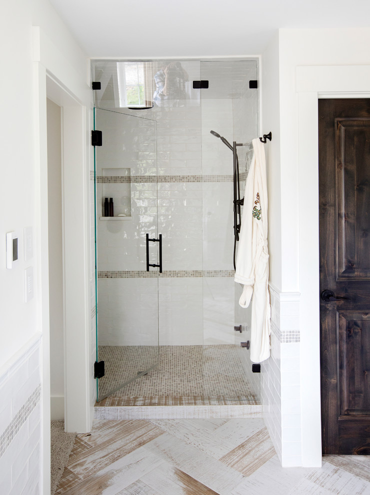 Inredning av ett lantligt badrum, med skåp i shakerstil, blå skåp, ett hörnbadkar, en dusch i en alkov, vit kakel, marmorkakel, bruna väggar, mörkt trägolv, ett integrerad handfat, marmorbänkskiva, brunt golv och dusch med gångjärnsdörr