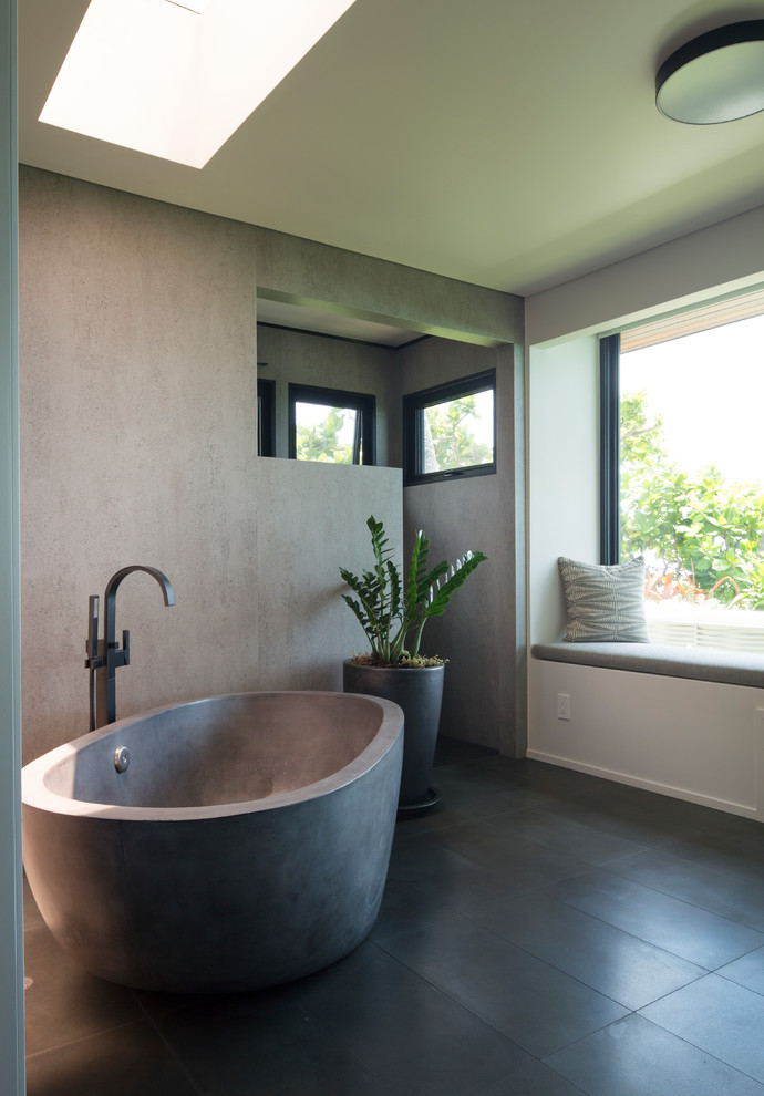 Immagine di una stanza da bagno minimal con vasca freestanding, pareti grigie e pavimento grigio