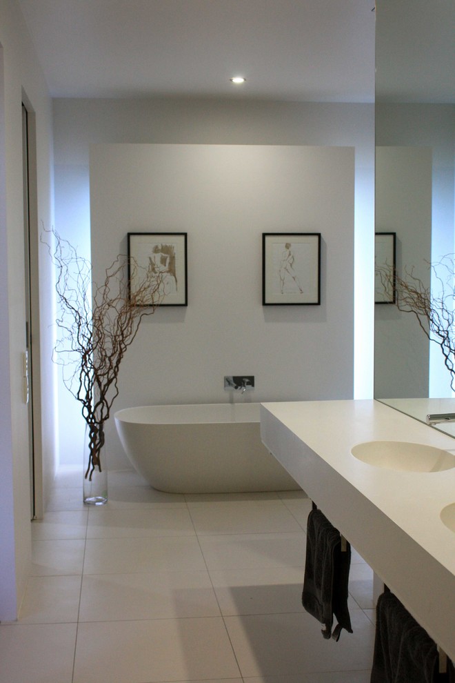Inspiration för stora moderna badrum, med ett integrerad handfat, ett fristående badkar, beige kakel, vita väggar och klinkergolv i keramik