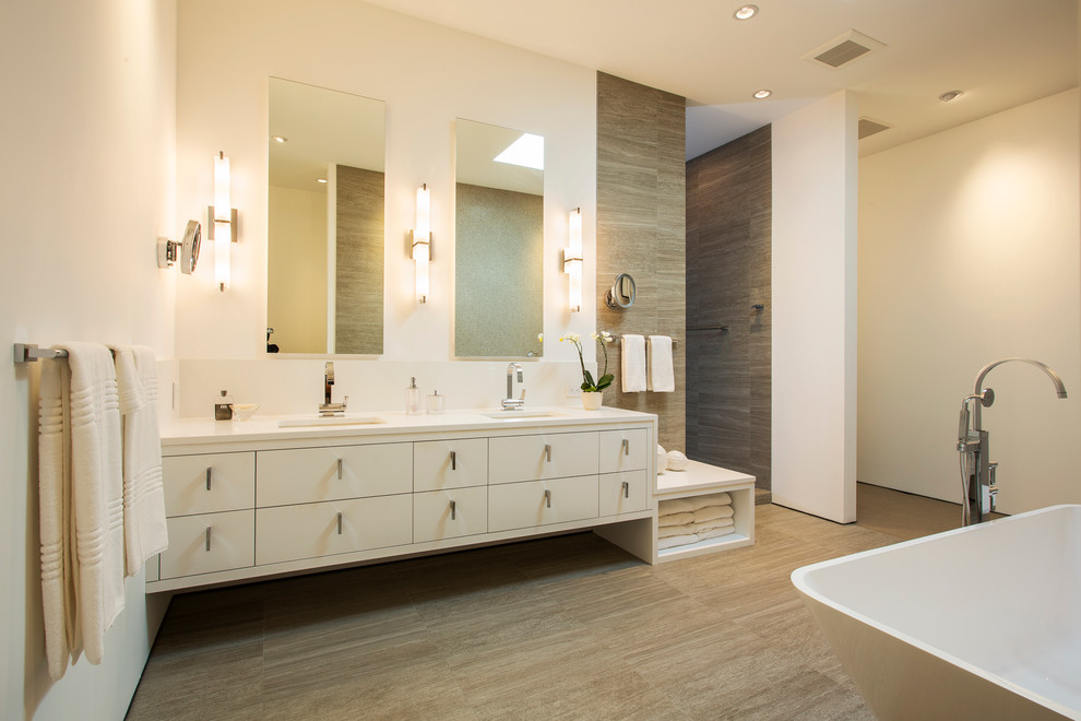 Exemple d'une salle de bain tendance avec un lavabo encastré, un placard à porte plane, des portes de placard blanches, une baignoire indépendante, une douche ouverte, un carrelage gris, un mur blanc et aucune cabine.