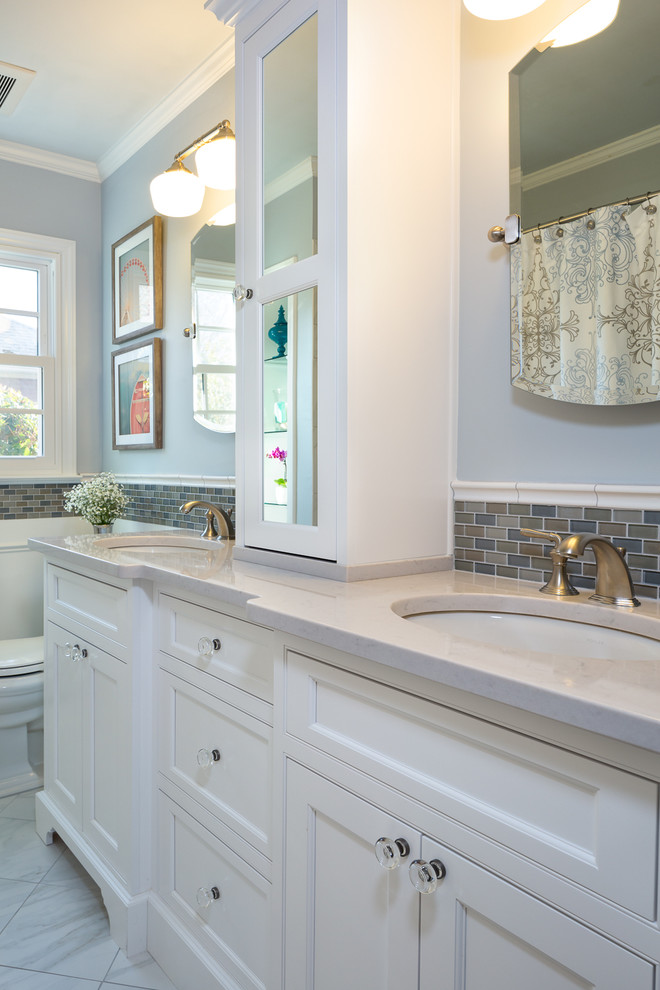 Exempel på ett litet klassiskt badrum, med ett undermonterad handfat, vita skåp, bänkskiva i kvarts, ett badkar i en alkov, en dusch/badkar-kombination, en toalettstol med separat cisternkåpa, vit kakel, porslinskakel, grå väggar, klinkergolv i porslin och luckor med infälld panel