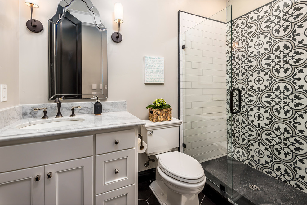 Cette photo montre une salle de bain chic avec un placard à porte shaker, des portes de placard blanches, WC séparés, un carrelage noir et blanc, un mur beige, un lavabo encastré et un sol noir.