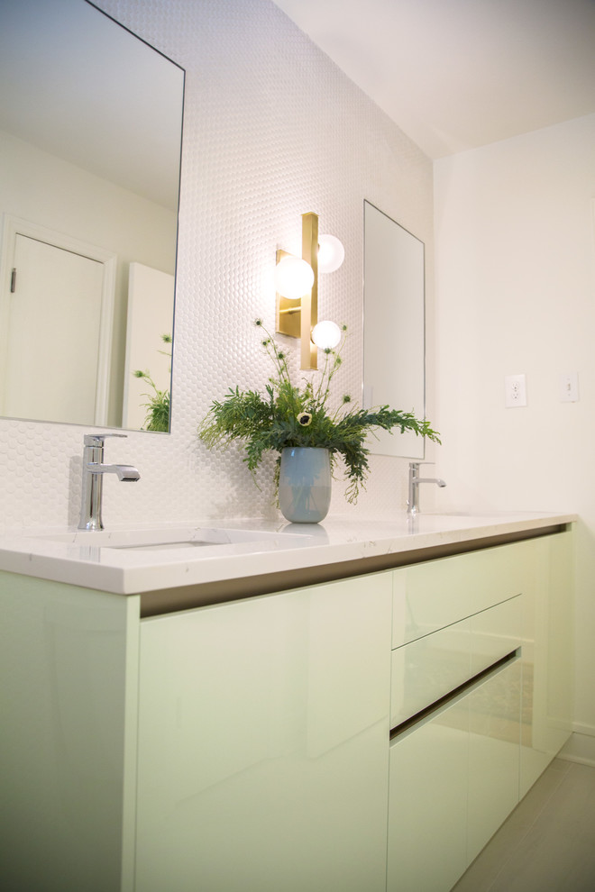 Идея дизайна: ванная комната в стиле модернизм с плоскими фасадами, зелеными фасадами, душем в нише, черно-белой плиткой, керамической плиткой, белыми стенами, полом из ламината, душевой кабиной, накладной раковиной, столешницей из гранита, белым полом и душем с распашными дверями