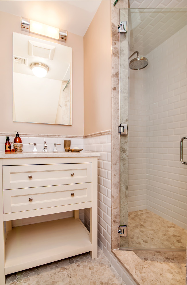 Doorless shower - traditional gray tile and mosaic tile marble floor doorless shower idea in New York with furniture-like cabinets, white cabinets, a one-piece toilet, beige walls, an undermount sink and marble countertops