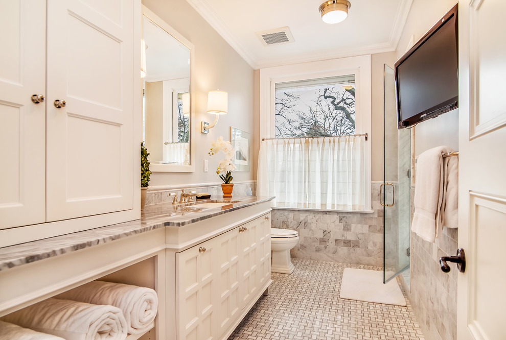 На фото: ванная комната в классическом стиле с фасадами с утопленной филенкой, белыми фасадами, открытым душем, унитазом-моноблоком, серой плиткой, плиткой мозаикой, бежевыми стенами, мраморным полом, врезной раковиной и мраморной столешницей