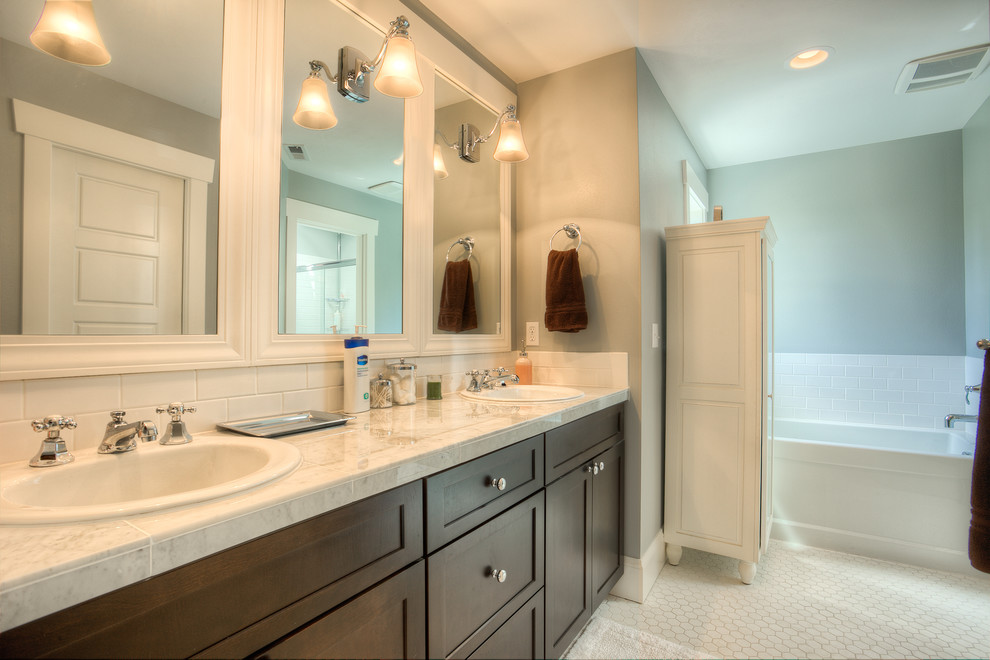 Example of a large arts and crafts master white tile and ceramic tile terra-cotta tile drop-in bathtub design in Seattle with shaker cabinets, dark wood cabinets, a one-piece toilet, blue walls, a drop-in sink and marble countertops