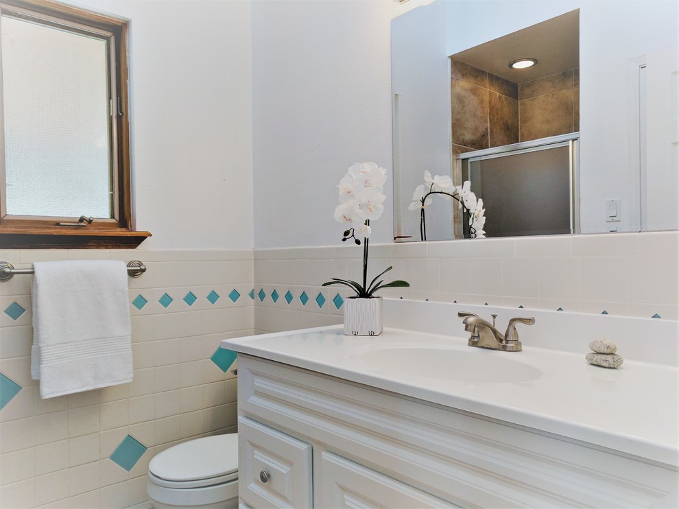 Cette image montre une petite salle de bain principale sud-ouest américain avec des portes de placard blanches, un carrelage blanc, des carreaux de céramique, un mur blanc, tomettes au sol et un sol rouge.