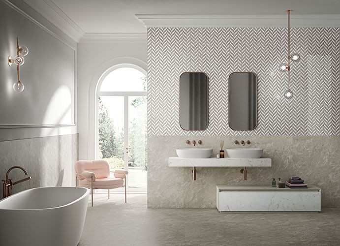 Foto på ett funkis badrum, med ett fristående badkar, porslinskakel, klinkergolv i porslin, ett väggmonterat handfat och kaklad bänkskiva
