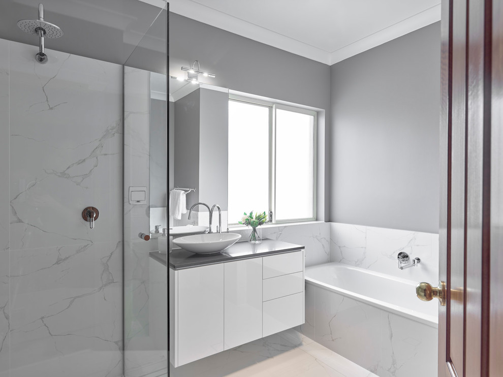 Inspiration for a large transitional master white tile and porcelain tile porcelain tile and white floor bathroom remodel in Other with flat-panel cabinets, white cabinets, a two-piece toilet, gray walls, a vessel sink, quartz countertops and gray countertops