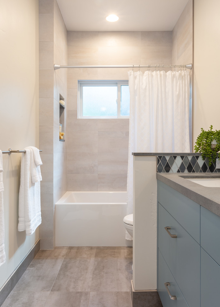 Inspiration för mellanstora moderna grått badrum, med släta luckor, blå skåp, ett badkar i en alkov, en dusch/badkar-kombination, grå kakel, porslinskakel, grå väggar, klinkergolv i porslin, ett undermonterad handfat, bänkskiva i kvarts, grått golv och dusch med duschdraperi
