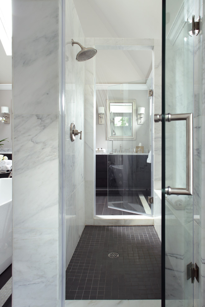 Inredning av ett klassiskt mycket stort en-suite badrum, med möbel-liknande, svarta skåp, ett fristående badkar, en dubbeldusch, en toalettstol med separat cisternkåpa, grå kakel, marmorkakel, grå väggar, klinkergolv i porslin, ett integrerad handfat, marmorbänkskiva, grått golv och dusch med gångjärnsdörr