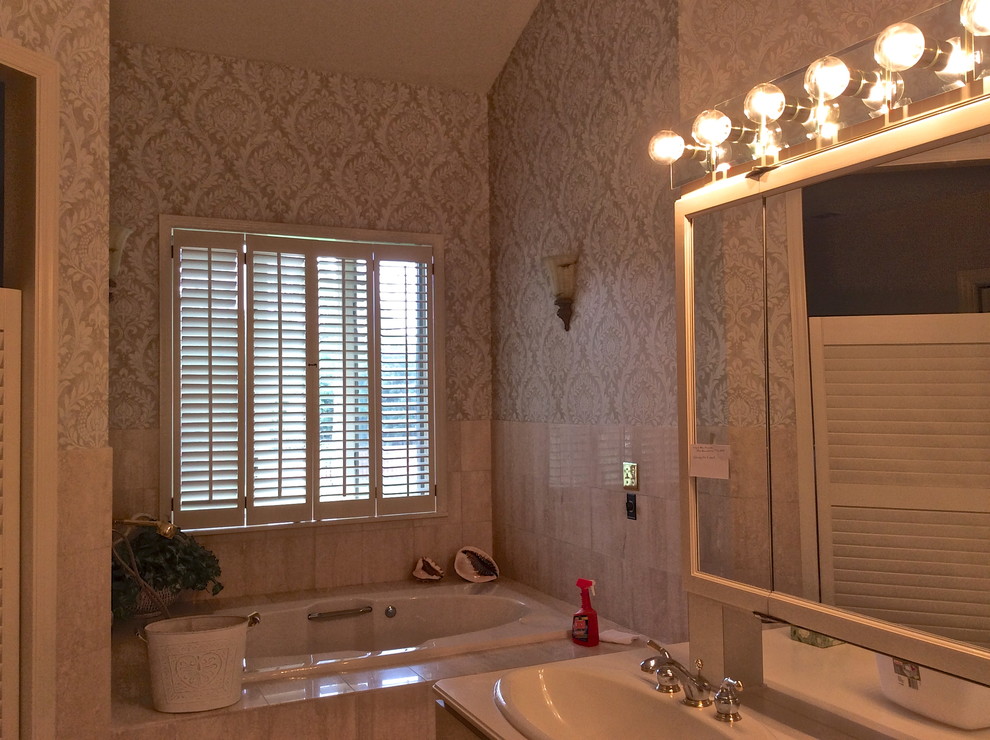Immagine di un'ampia stanza da bagno padronale classica con lavabo da incasso, ante lisce, ante beige, top in superficie solida, vasca ad alcova, doccia alcova, WC a due pezzi, piastrelle beige, piastrelle in pietra e pareti beige