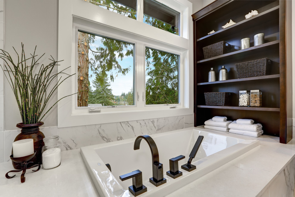 Large modern ensuite bathroom in DC Metro with shaker cabinets, brown cabinets, a built-in bath, a built-in shower, a two-piece toilet, white tiles, porcelain tiles, white walls, porcelain flooring, a submerged sink, engineered stone worktops, white floors, a hinged door and white worktops.