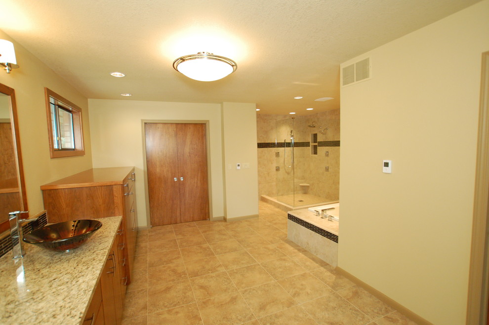 Photo of a large classic ensuite bathroom in Boise with a submerged sink, flat-panel cabinets, medium wood cabinets, granite worktops, a built-in bath, a corner shower, beige tiles, ceramic tiles, yellow walls and ceramic flooring.