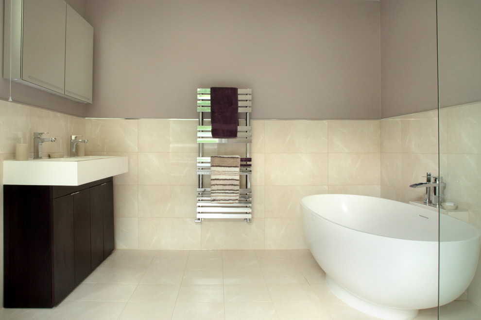 Modelo de cuarto de baño infantil actual de tamaño medio con bañera exenta, ducha abierta, baldosas y/o azulejos beige y paredes púrpuras