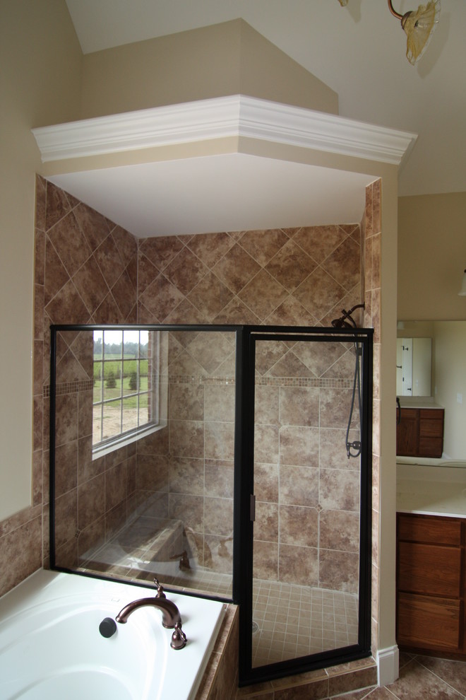 Bathroom - large traditional master ceramic tile and brown tile ceramic tile bathroom idea in Raleigh with an integrated sink, raised-panel cabinets, medium tone wood cabinets, solid surface countertops, a one-piece toilet and beige walls