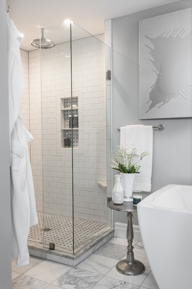 Стильный дизайн: главная ванная комната среднего размера в классическом стиле с фасадами островного типа, синими фасадами, отдельно стоящей ванной, угловым душем, раздельным унитазом, белой плиткой, мраморной плиткой, серыми стенами, мраморным полом, врезной раковиной, мраморной столешницей, белым полом, душем с распашными дверями и белой столешницей - последний тренд