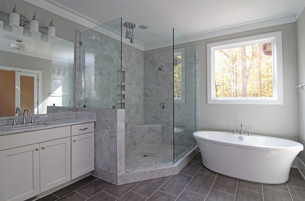 Example of a large arts and crafts master ceramic tile and gray floor bathroom design in Raleigh with recessed-panel cabinets, white cabinets, a one-piece toilet, gray walls, an undermount sink, marble countertops and white countertops