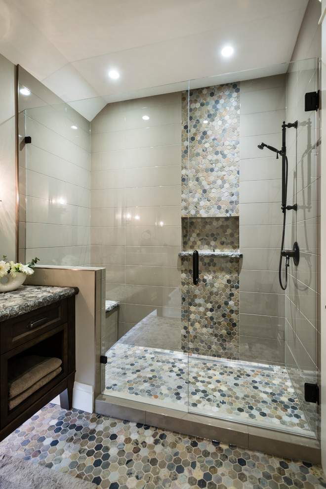 Large classic shower room bathroom in Vancouver with recessed-panel cabinets, brown cabinets, an alcove shower, a two-piece toilet, grey tiles, porcelain tiles, beige walls, mosaic tile flooring, a built-in sink, granite worktops, multi-coloured floors and a hinged door.