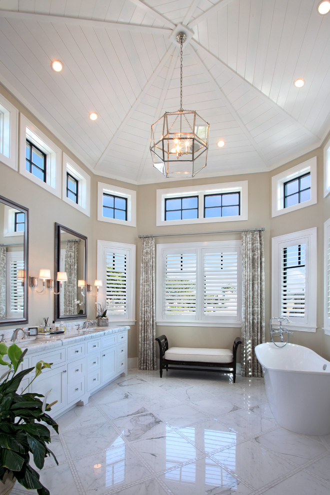 Transitional white tile marble floor freestanding bathtub photo in Orange County with an undermount sink, shaker cabinets, white cabinets, marble countertops and beige walls