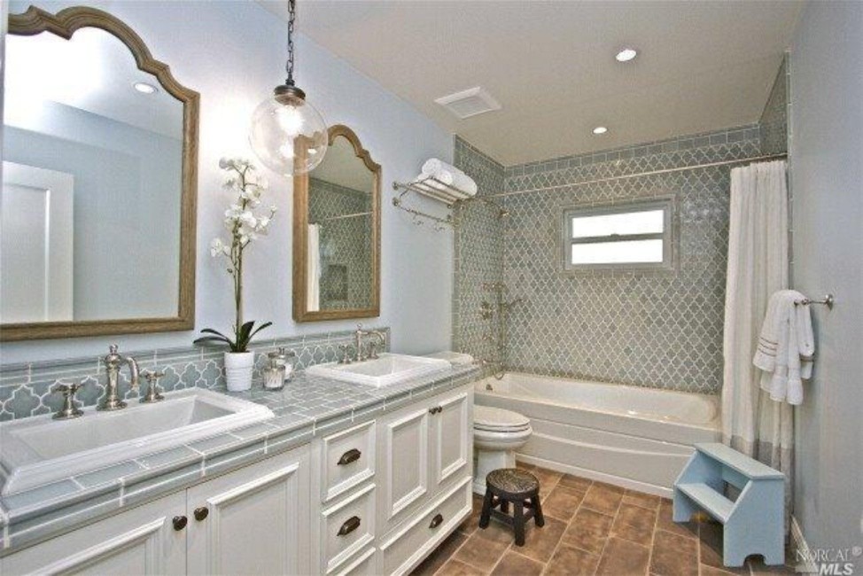 Inredning av ett klassiskt mellanstort en-suite badrum, med luckor med upphöjd panel, vita skåp, ett hörnbadkar, en öppen dusch, en toalettstol med hel cisternkåpa, blå kakel, porslinskakel, blå väggar, klinkergolv i keramik, ett nedsänkt handfat och kaklad bänkskiva