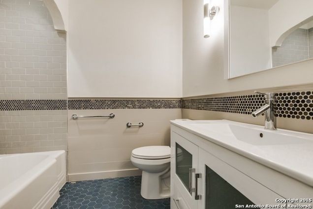Стильный дизайн: ванная комната среднего размера в стиле ретро с фасадами в стиле шейкер, белыми фасадами, ванной в нише, душем над ванной, раздельным унитазом, белыми стенами, душевой кабиной, монолитной раковиной, синим полом и шторкой для ванной - последний тренд