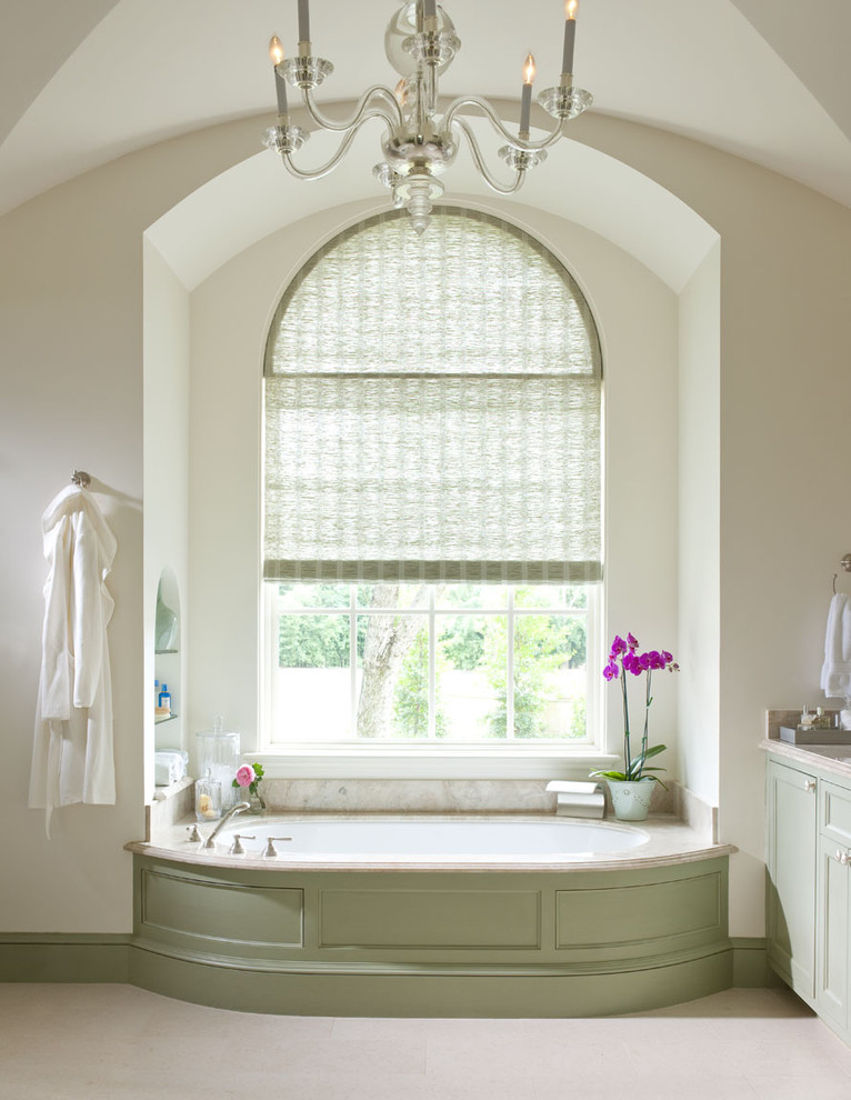 Стильный дизайн: ванная комната в классическом стиле с фасадами с утопленной филенкой, зелеными фасадами, ванной в нише, бежевой плиткой и окном - последний тренд