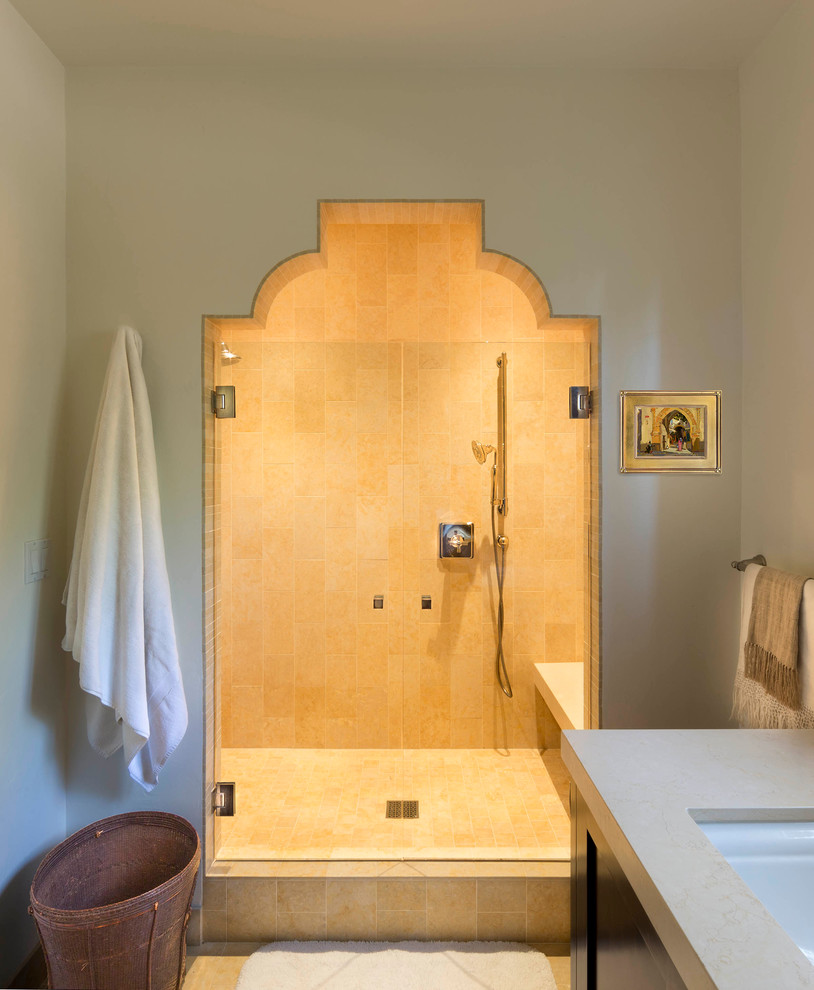 Cette photo montre une douche en alcôve principale méditerranéenne en bois foncé de taille moyenne avec un placard à porte shaker, WC séparés, un carrelage beige, un carrelage de pierre, un mur blanc, un sol en calcaire, un lavabo encastré et un plan de toilette en calcaire.