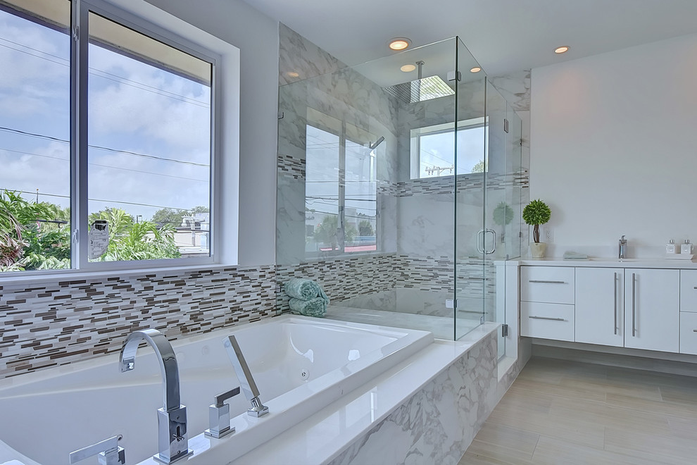 Inspiration for a large modern master gray tile and porcelain tile porcelain tile corner shower remodel in Miami with flat-panel cabinets, white cabinets, a hot tub, a one-piece toilet, an undermount sink, quartz countertops and white walls