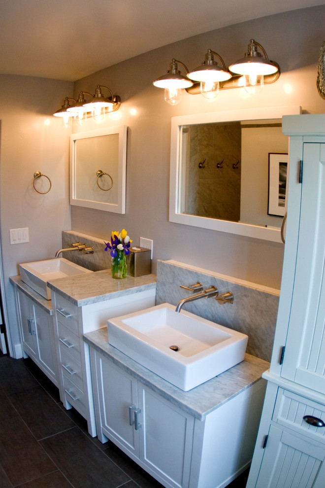 Cette photo montre une petite douche en alcôve principale craftsman avec une vasque, un placard à porte shaker, des portes de placard blanches, un plan de toilette en granite, un carrelage gris, un mur gris, un sol en carrelage de porcelaine et un sol marron.