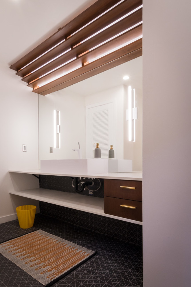 Bathroom - large scandinavian master black tile and mosaic tile porcelain tile and black floor bathroom idea in Los Angeles with flat-panel cabinets, medium tone wood cabinets, a one-piece toilet, white walls, an integrated sink, quartz countertops and a hinged shower door