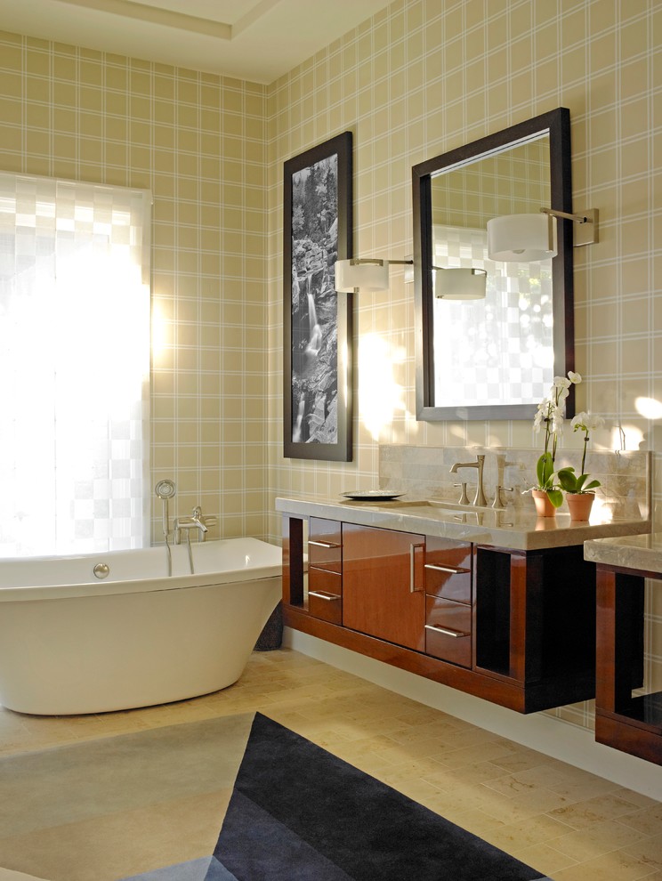 Diseño de cuarto de baño actual con lavabo bajoencimera, armarios con paneles lisos, puertas de armario de madera en tonos medios, bañera exenta y paredes multicolor