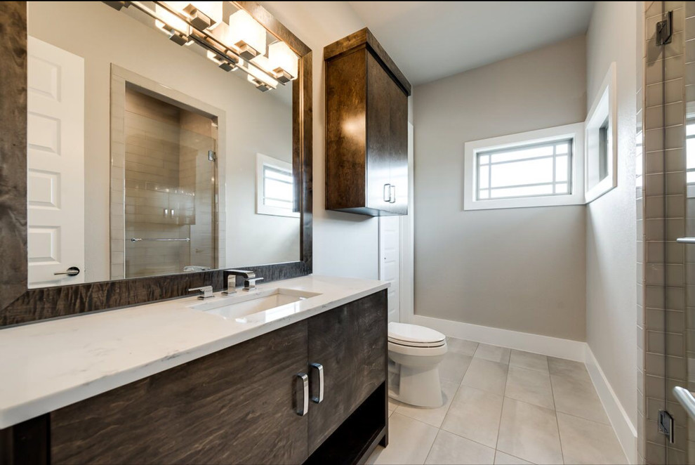 Пример оригинального дизайна: ванная комната среднего размера в современном стиле с плоскими фасадами, темными деревянными фасадами, раздельным унитазом, белой плиткой, бежевыми стенами, полом из керамической плитки, душевой кабиной, настольной раковиной и столешницей из искусственного камня
