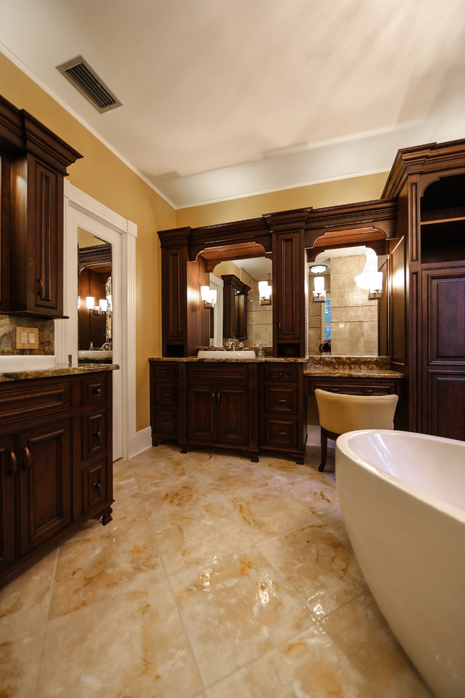 Inspiration for a traditional ensuite bathroom in Orlando with beaded cabinets, dark wood cabinets, a freestanding bath, a corner shower, beige tiles, black tiles, beige walls, a built-in sink, granite worktops, beige floors and a hinged door.