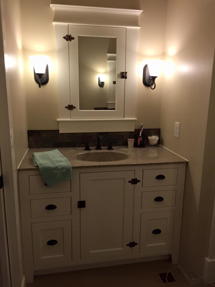 Immagine di una stanza da bagno classica di medie dimensioni con ante lisce, ante bianche, doccia ad angolo, piastrelle marroni, pareti beige, lavabo integrato e top in superficie solida