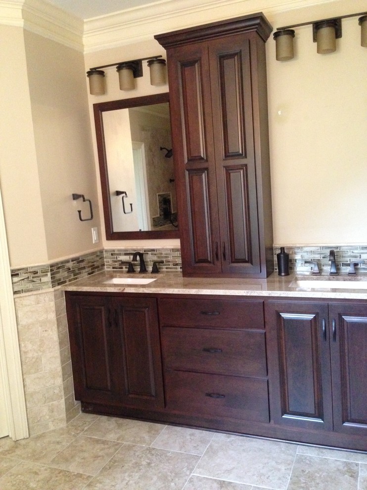 Example of a classic master beige tile and porcelain tile porcelain tile bathroom design in Atlanta with an undermount sink, raised-panel cabinets, dark wood cabinets, granite countertops and brown walls
