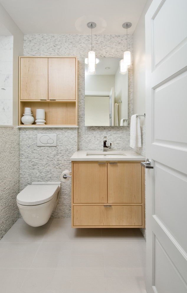 Idéer för att renovera ett litet funkis badrum, med ett undermonterad handfat, släta luckor, skåp i ljust trä, bänkskiva i kvarts, en vägghängd toalettstol, vit kakel, stenkakel, grå väggar och klinkergolv i porslin