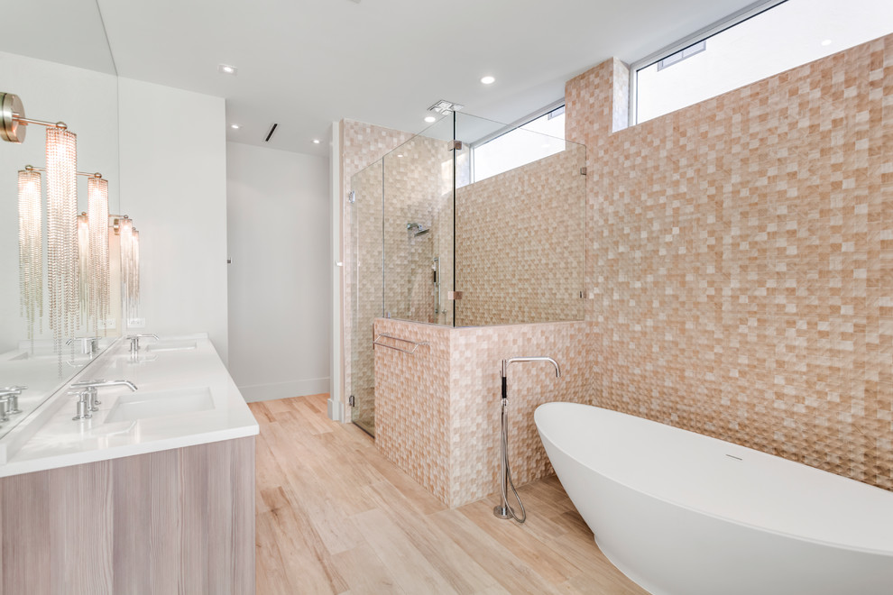 Exemple d'une salle de bain principale tendance en bois clair avec une baignoire indépendante, une douche d'angle, un carrelage beige, un mur blanc, un lavabo encastré, un sol beige, une cabine de douche à porte battante et un plan de toilette blanc.