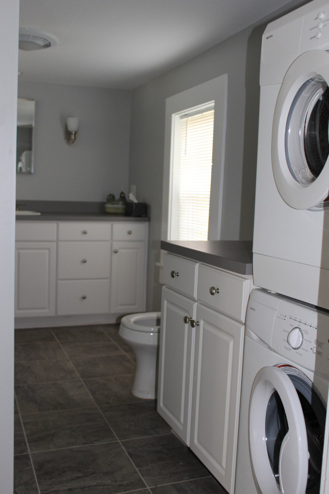 Exempel på ett stort grå grått en-suite badrum, med luckor med infälld panel, grå skåp, en hörndusch, en toalettstol med hel cisternkåpa, vita väggar, klinkergolv i keramik, ett nedsänkt handfat, laminatbänkskiva, grått golv och dusch med gångjärnsdörr