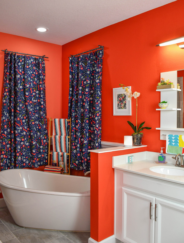 На фото: большая главная ванная комната в стиле фьюжн с белыми фасадами, накладной ванной, унитазом-моноблоком, оранжевой плиткой, оранжевыми стенами, монолитной раковиной, мраморной столешницей, душем с распашными дверями и бежевой столешницей с