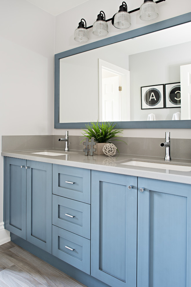 Immagine di una stanza da bagno per bambini classica di medie dimensioni con lavabo sottopiano, ante in stile shaker, ante blu, top in quarzo composito, pareti grigie e pavimento in gres porcellanato