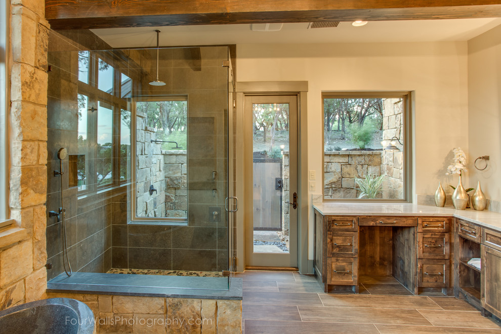 Cette image montre une salle de bain chalet en bois brun avec un placard sans porte, une baignoire indépendante, WC à poser, un mur beige, un sol en bois brun, un lavabo intégré et un plan de toilette en bois.