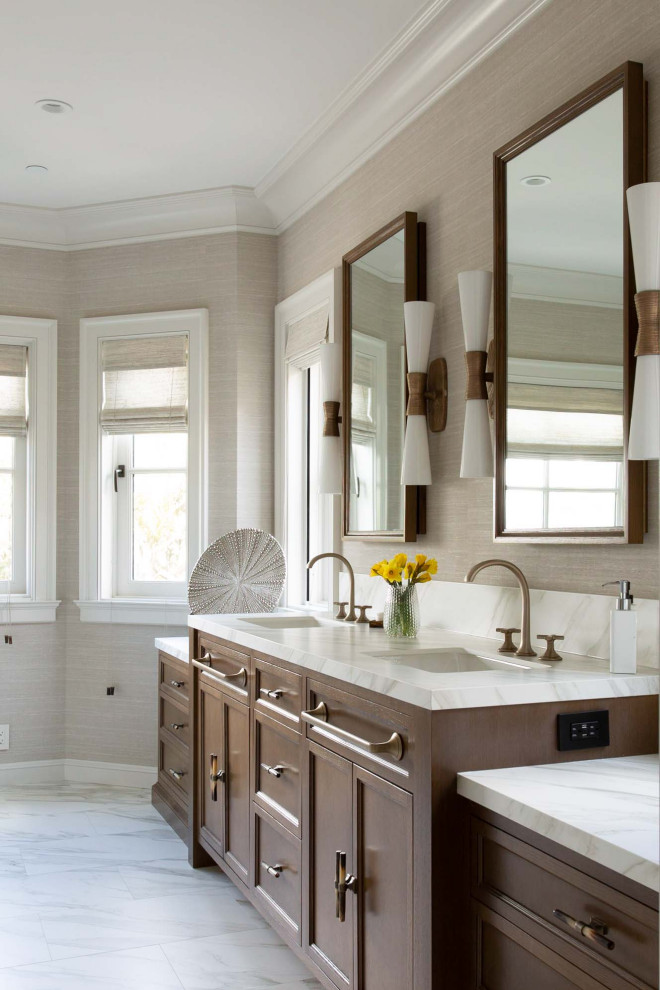 Modelo de cuarto de baño clásico renovado con armarios con paneles empotrados, puertas de armario de madera en tonos medios, paredes grises, lavabo bajoencimera, suelo blanco y encimeras blancas