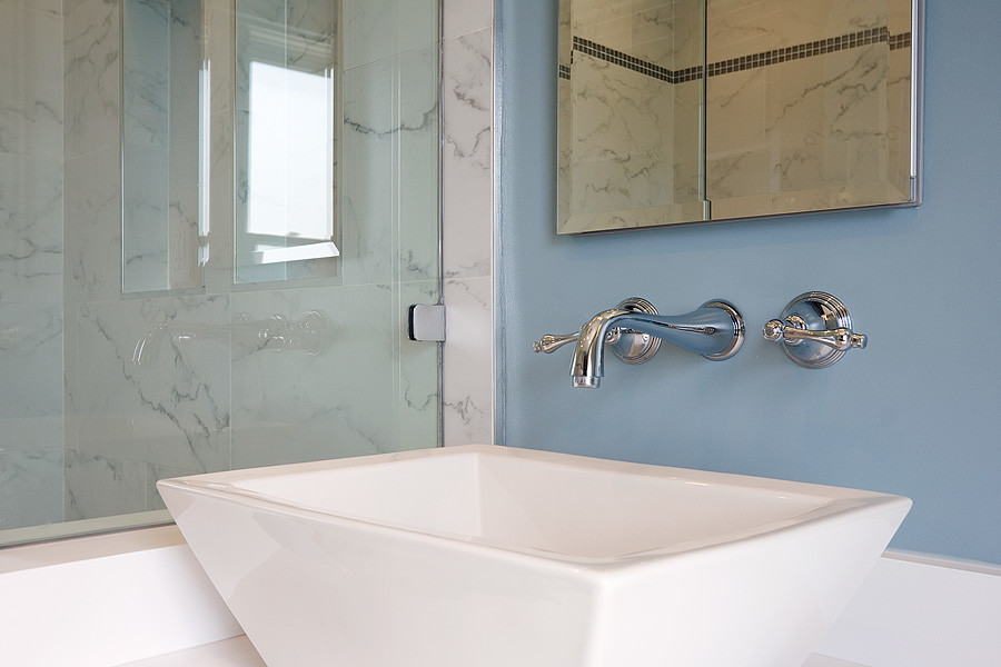 Foto di una stanza da bagno con doccia moderna di medie dimensioni con ante lisce, ante bianche, vasca ad alcova, doccia alcova, WC a due pezzi, piastrelle bianche, pareti blu, lavabo da incasso e top in superficie solida