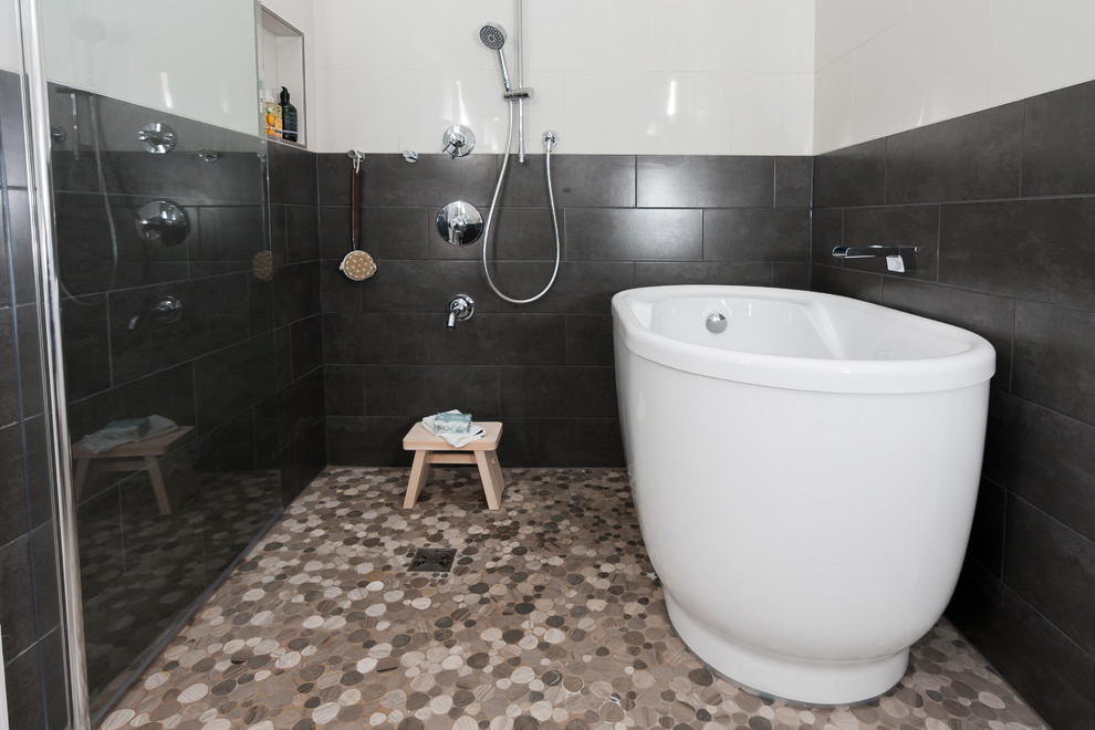 Cette photo montre une salle de bain principale asiatique de taille moyenne avec un placard à porte shaker, des portes de placard grises, une baignoire indépendante, un espace douche bain, WC séparés, un carrelage beige, des carreaux de porcelaine, un mur beige, un sol en carrelage de porcelaine, un lavabo encastré, un plan de toilette en quartz modifié, un sol beige et une cabine de douche à porte battante.