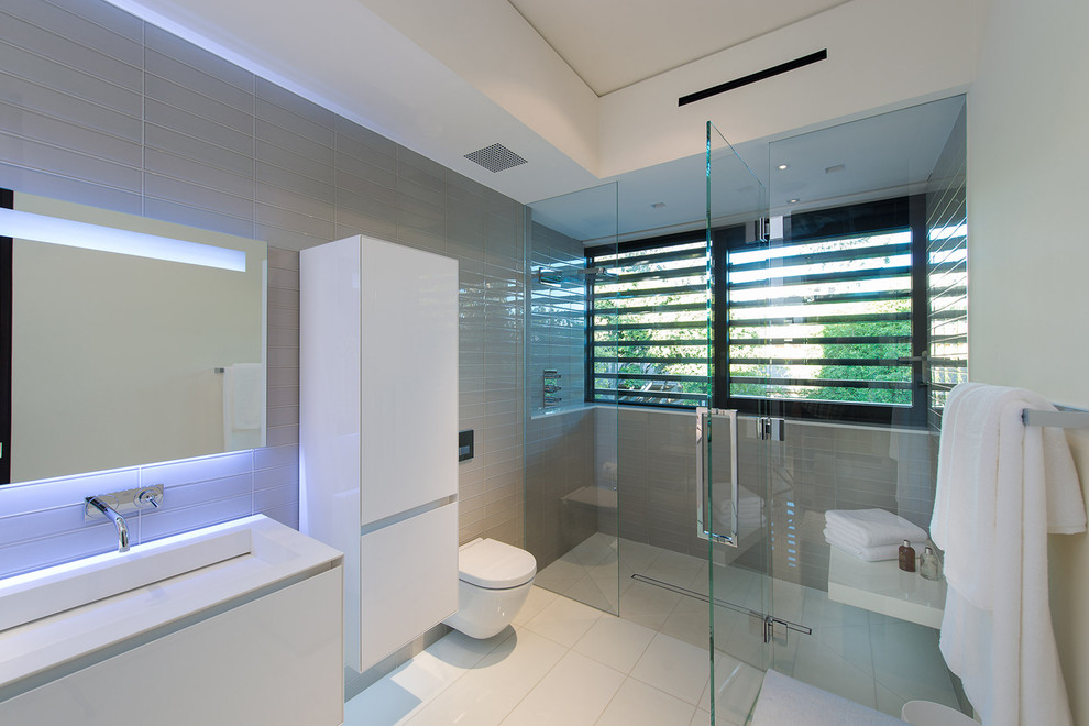 Idéer för mellanstora funkis vitt en-suite badrum, med vita skåp, en dusch i en alkov, en toalettstol med hel cisternkåpa, vita väggar, ett avlångt handfat, vitt golv och dusch med gångjärnsdörr