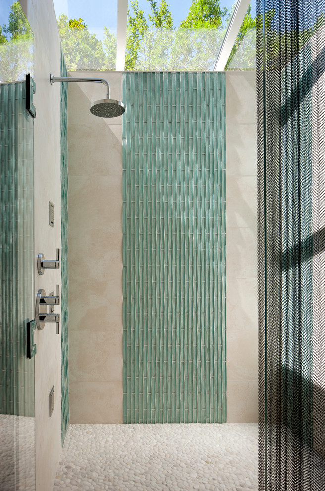 Imagen de cuarto de baño moderno con baldosas y/o azulejos azules, baldosas y/o azulejos de vidrio y suelo de baldosas tipo guijarro