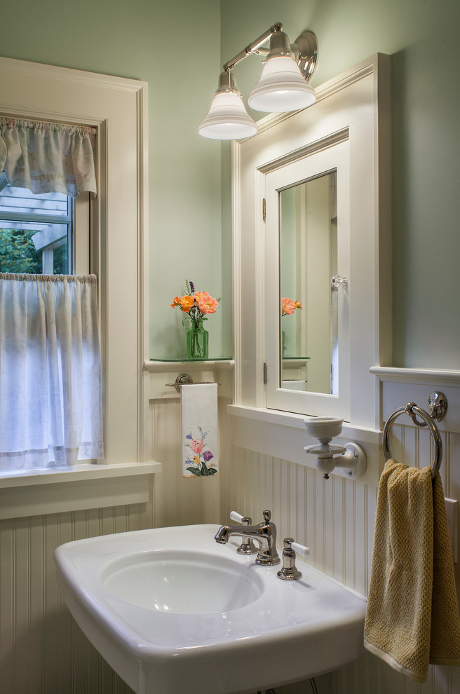 Small classic bathroom in Portland with beaded cabinets, white cabinets, green walls and a pedestal sink.