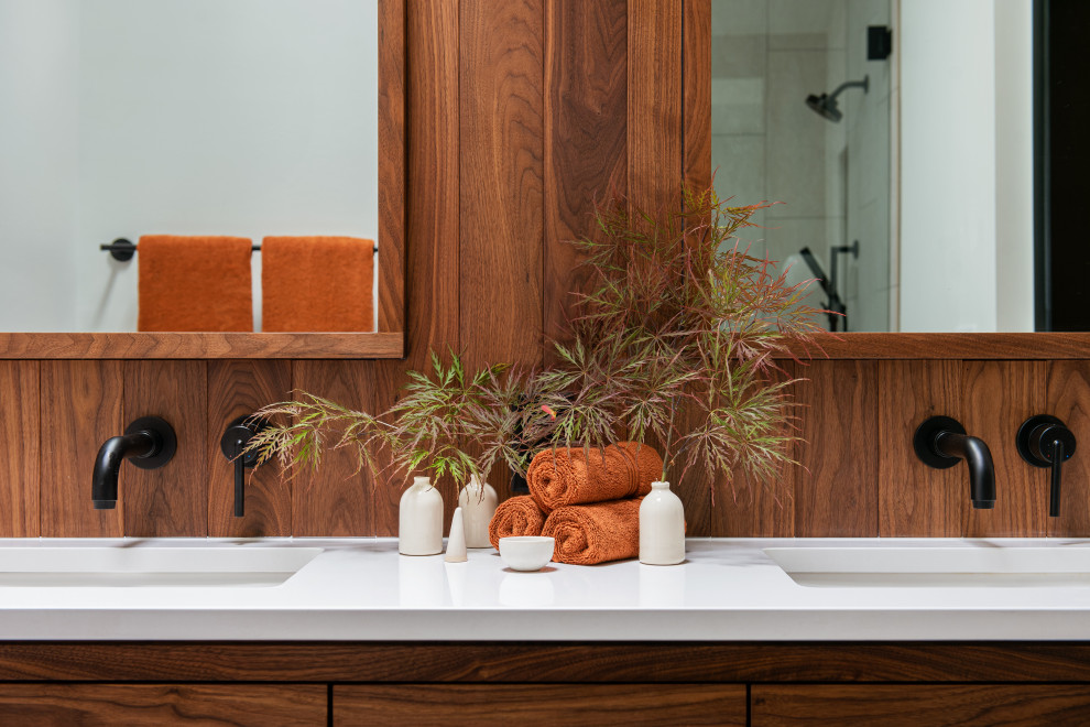 Пример оригинального дизайна: маленькая главная ванная комната в стиле модернизм с плоскими фасадами, коричневыми фасадами, ванной в нише, душем над ванной, унитазом-моноблоком, бежевой плиткой, керамогранитной плиткой, белыми стенами, полом из керамогранита, врезной раковиной, столешницей из искусственного кварца, черным полом, душем с распашными дверями и белой столешницей для на участке и в саду