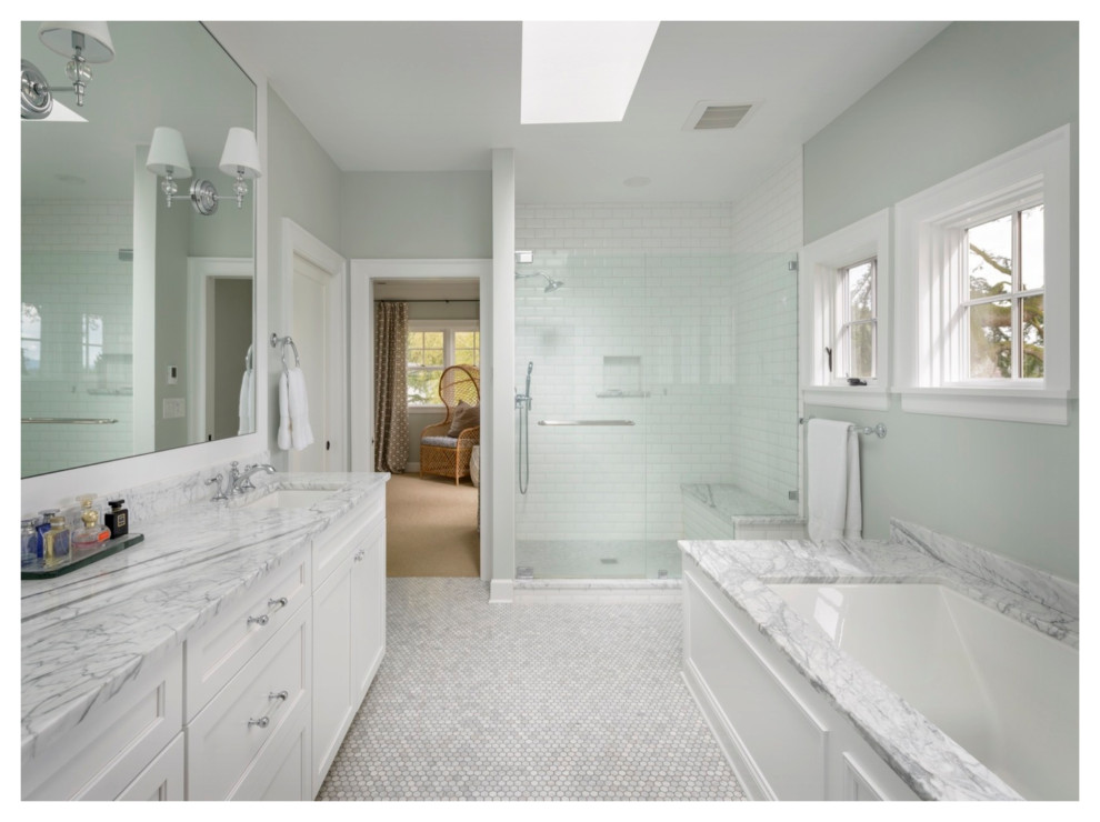Klassisk inredning av ett vit vitt badrum, med ett undermonterat badkar, våtrum, vit kakel, cementgolv, ett undermonterad handfat, marmorbänkskiva och dusch med gångjärnsdörr